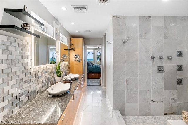 bathroom with tasteful backsplash, vanity, and tiled shower