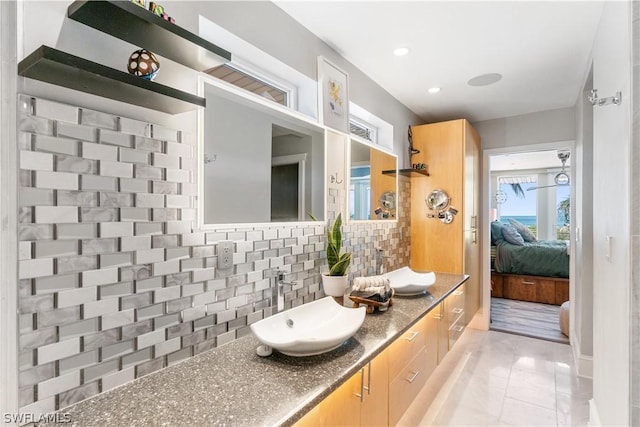 bathroom with vanity, tile patterned flooring, and decorative backsplash