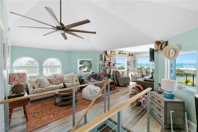 living room with a wealth of natural light, vaulted ceiling, and light wood-type flooring