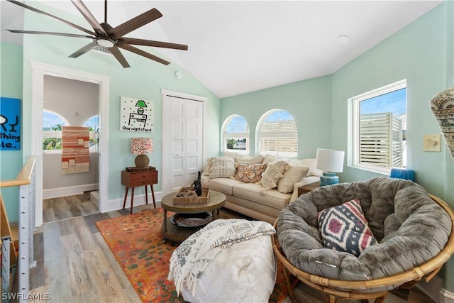 living room with vaulted ceiling, a wealth of natural light, ceiling fan, and light hardwood / wood-style flooring