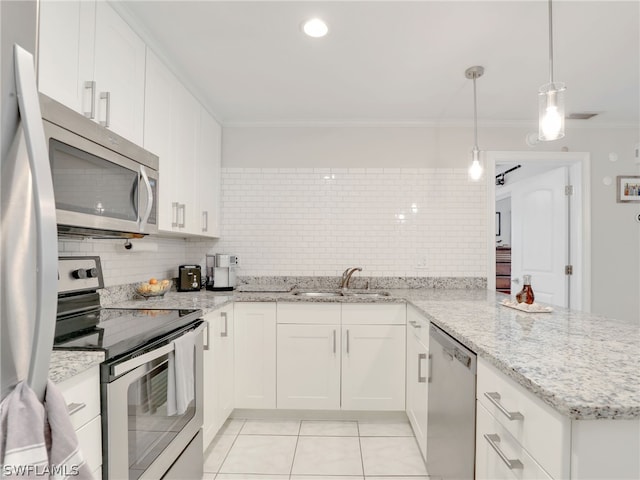 kitchen featuring a peninsula, a sink, appliances with stainless steel finishes, tasteful backsplash, and crown molding