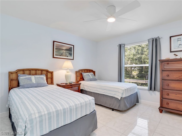 bedroom with light tile patterned floors, ceiling fan, and baseboards