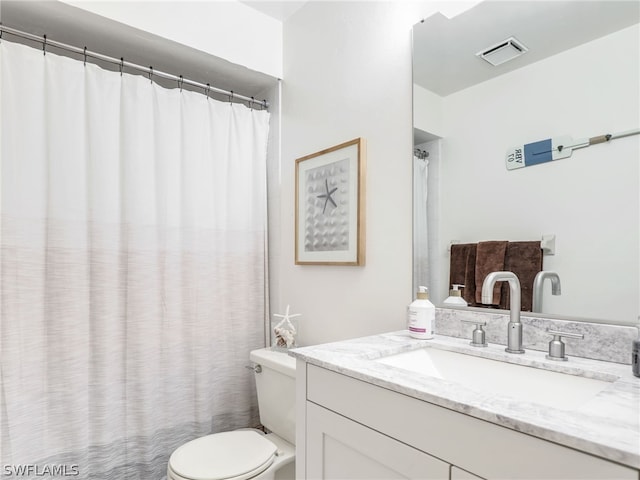 full bathroom with toilet, vanity, and visible vents