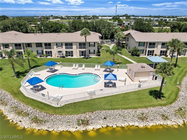 pool with a water view, fence, and a patio