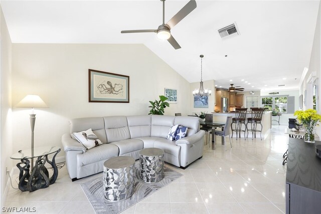 living room featuring ceiling fan with notable chandelier, lofted ceiling, and light tile patterned floors