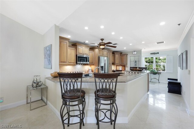 kitchen featuring backsplash, stainless steel appliances, ornamental molding, and light tile patterned floors