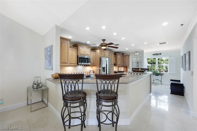18080 San Carlos Blvd Unit 724, Fort Myers Beach, FL 33931 - kitchen featuring visible vents, a peninsula, stainless steel appliances, a kitchen bar, and backsplash