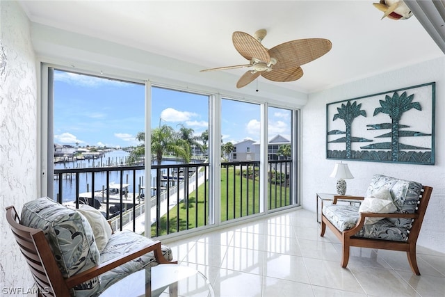 sunroom featuring a water view and ceiling fan