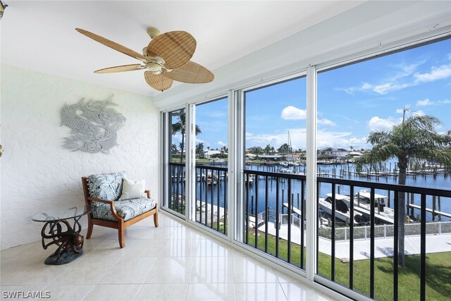 sunroom / solarium with a water view, a healthy amount of sunlight, and ceiling fan