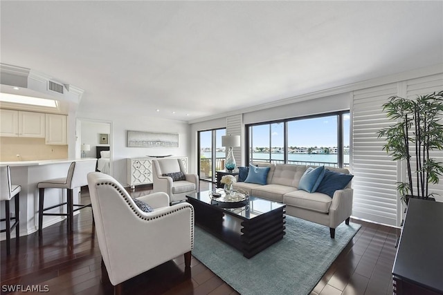 living room featuring a water view, dark wood-type flooring, and ornamental molding