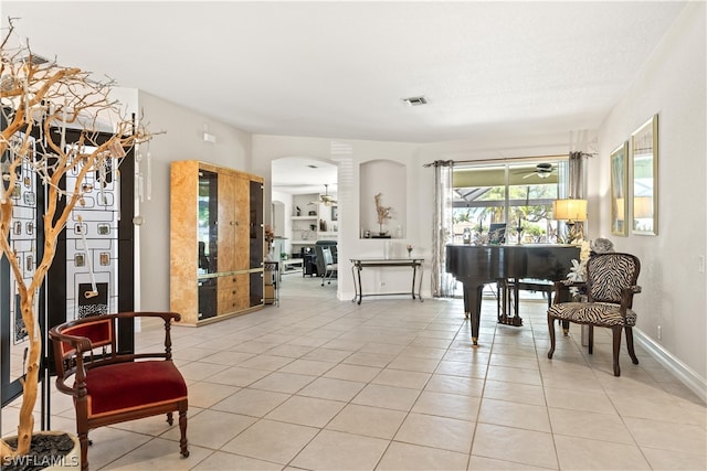 interior space with ceiling fan and light tile floors