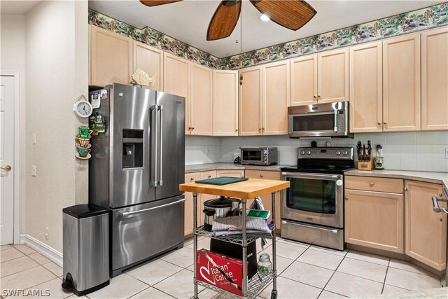 kitchen featuring ceiling fan, stainless steel appliances, and light tile flooring