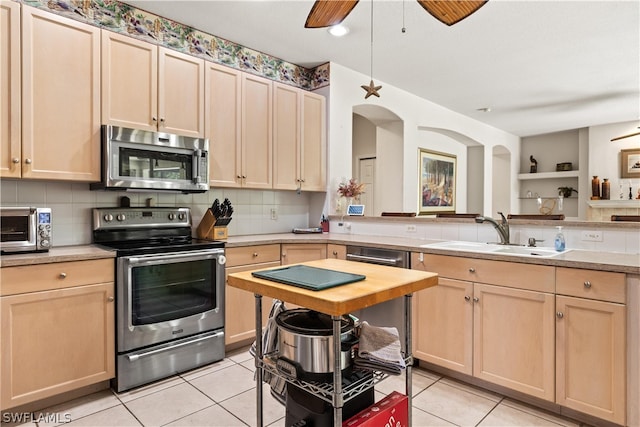 kitchen featuring backsplash, appliances with stainless steel finishes, sink, and ceiling fan