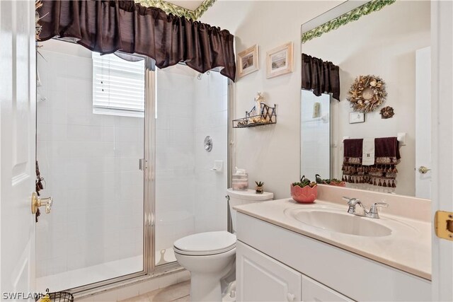 bathroom with vanity, toilet, and a shower with door