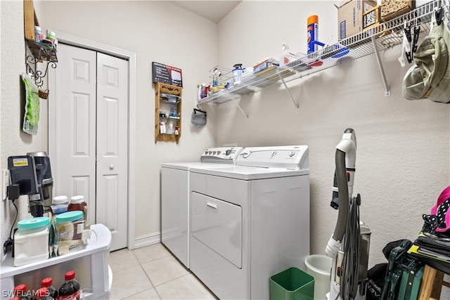 laundry area with washer and dryer and light tile floors