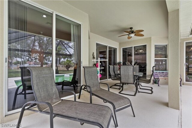 view of terrace featuring ceiling fan and a swimming pool