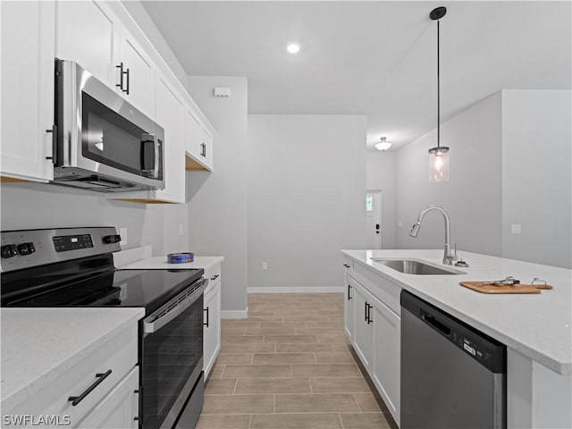 kitchen with decorative light fixtures, white cabinetry, sink, and appliances with stainless steel finishes