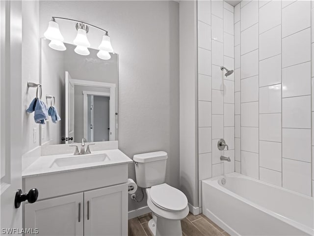 full bathroom featuring vanity, hardwood / wood-style flooring, toilet, and tiled shower / bath