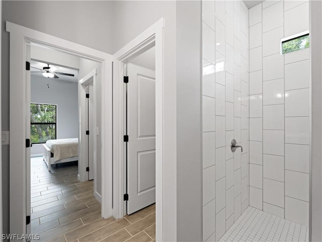 bathroom with ceiling fan and a tile shower