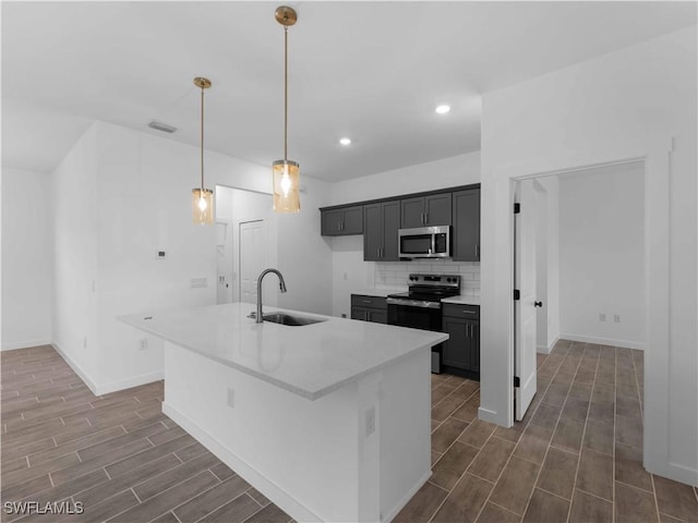 2917 NW 19th Ter, Cape Coral, FL 33993 - kitchen featuring a sink, appliances with stainless steel finishes, wood tiled floors, tasteful backsplash, and baseboards