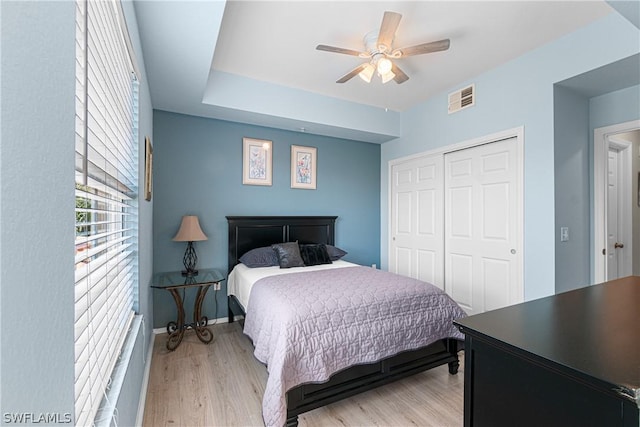 bedroom featuring ceiling fan, a closet, and light wood-type flooring