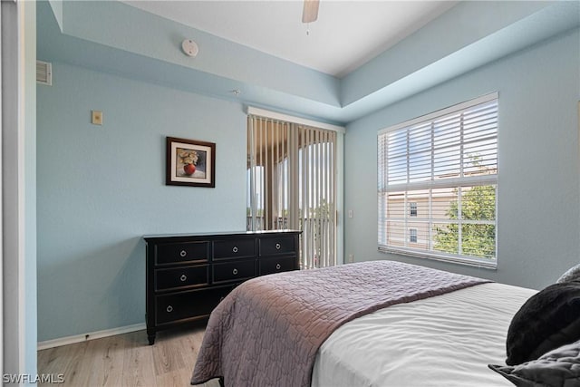 bedroom with ceiling fan, light hardwood / wood-style flooring, and multiple windows