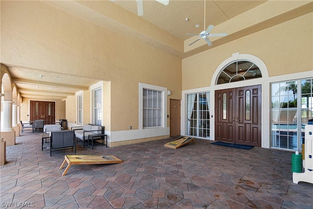 property entrance featuring ceiling fan and an outdoor living space