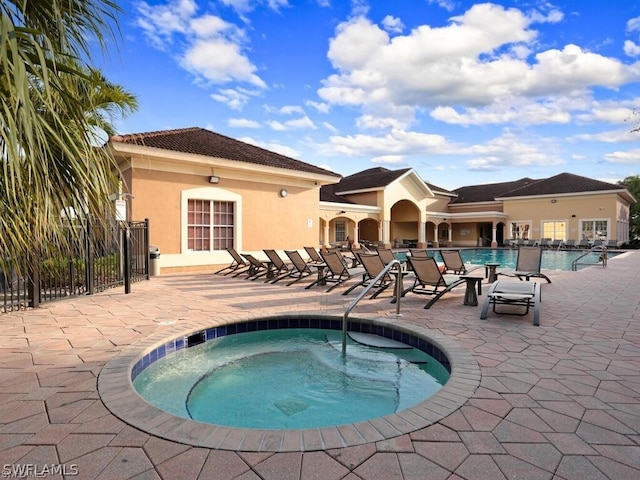 view of swimming pool with a patio and a hot tub