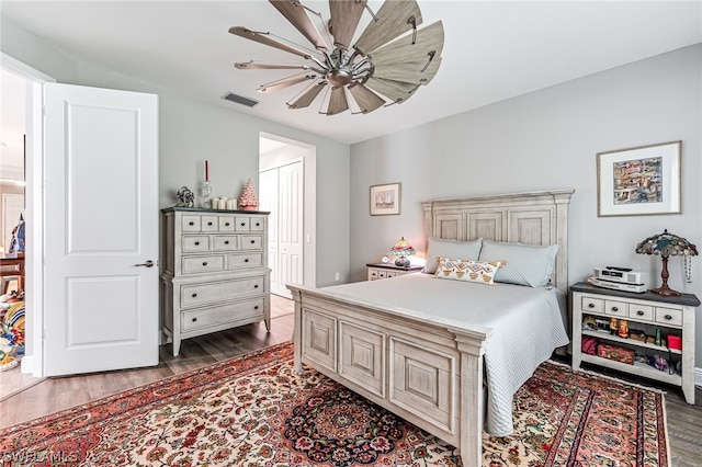 bedroom featuring ceiling fan, a closet, and dark wood-type flooring