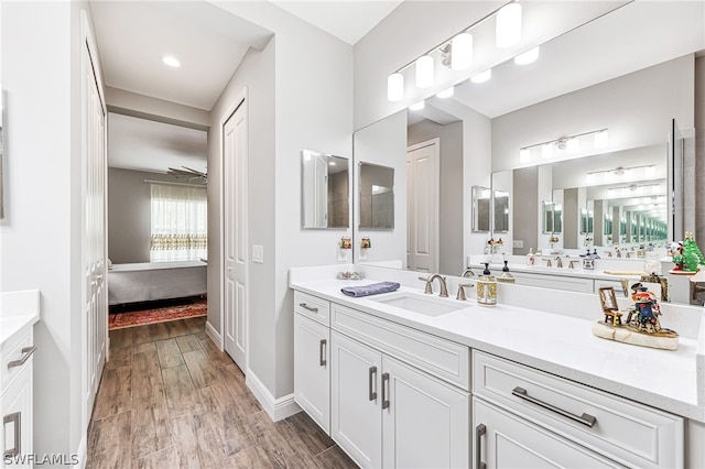 bathroom featuring wood-type flooring, vanity, and ceiling fan