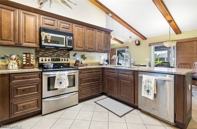 kitchen with kitchen peninsula, appliances with stainless steel finishes, hanging light fixtures, beam ceiling, and sink