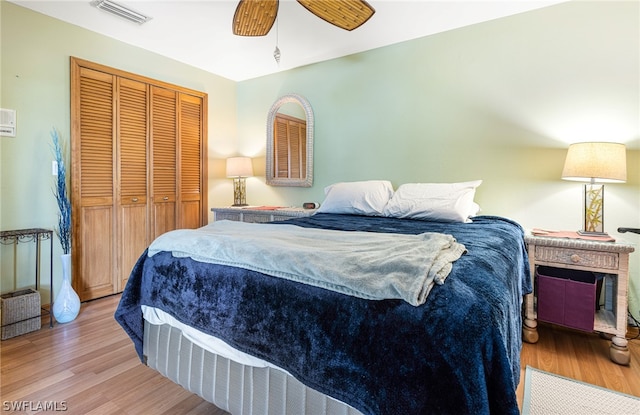 bedroom with a closet, light hardwood / wood-style flooring, and ceiling fan