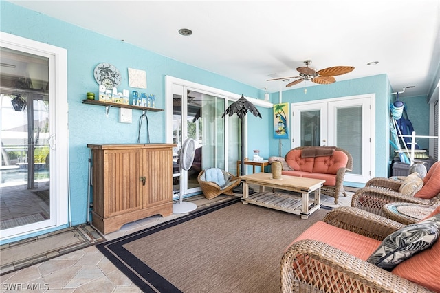 living room featuring ceiling fan and french doors