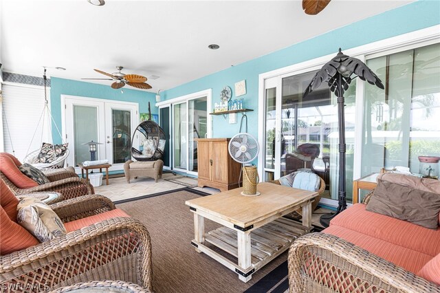 living room with ceiling fan, a wealth of natural light, and french doors