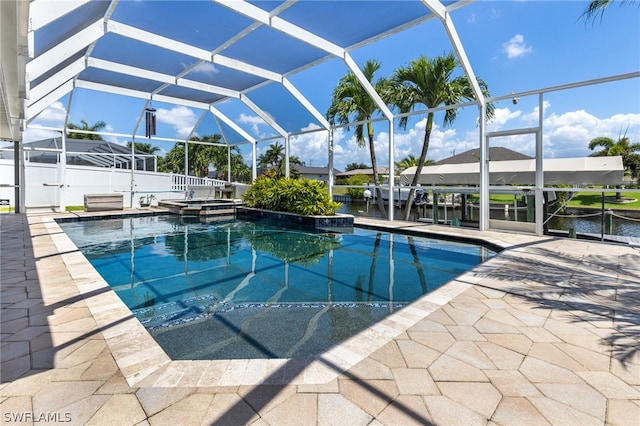 view of swimming pool with a lanai, a patio area, a water view, and an in ground hot tub