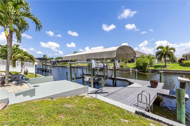 view of dock with a water view and a yard