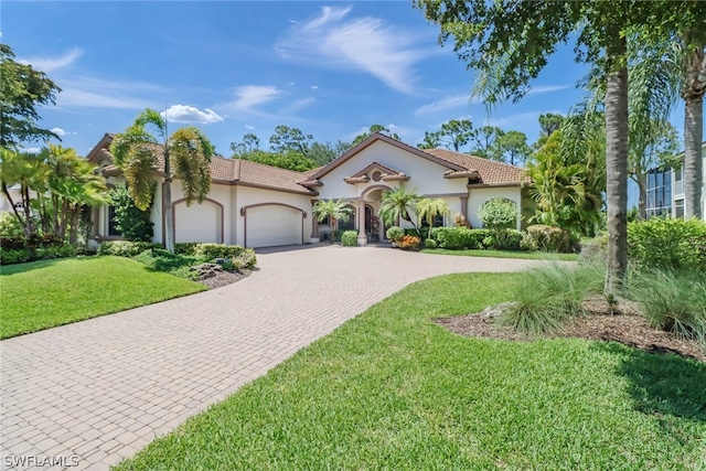 mediterranean / spanish-style house with a front yard and a garage