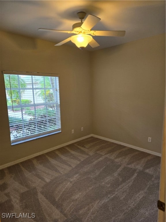 unfurnished room featuring dark colored carpet and ceiling fan