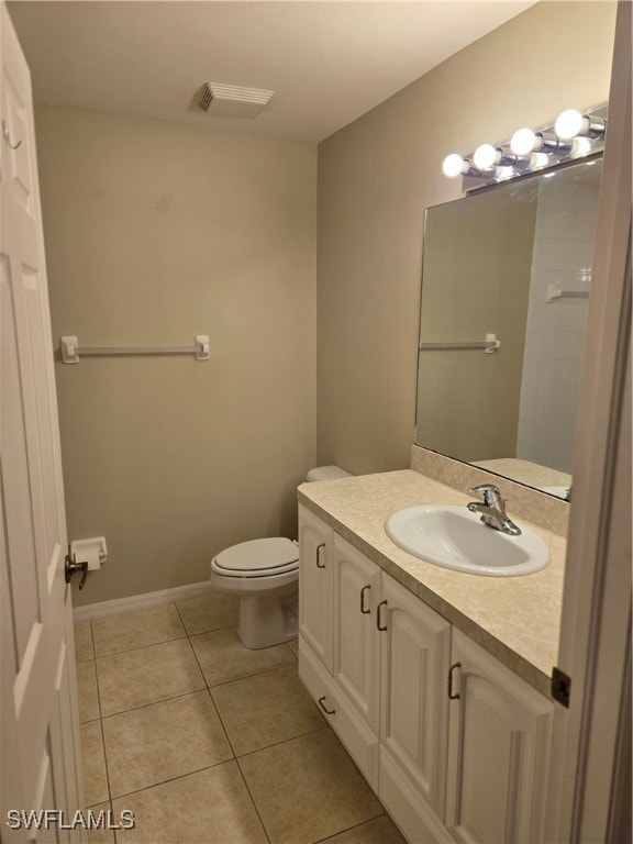 bathroom with vanity, tile patterned flooring, and toilet