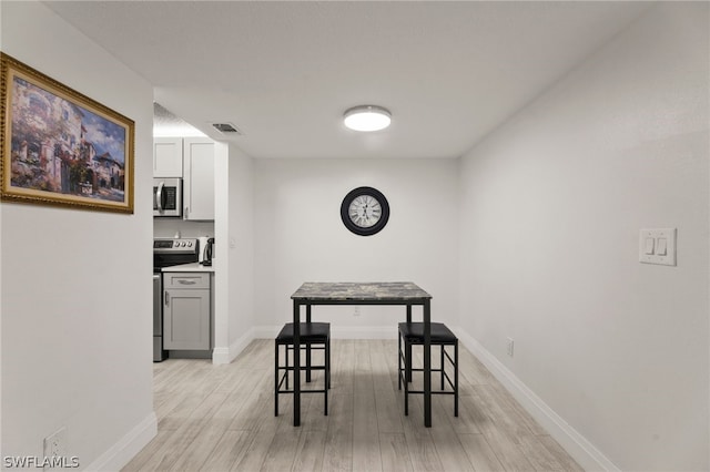 201 Santa Clara Dr Unit 13, Naples, FL 34104 - dining room with baseboards, light wood-type flooring, and visible vents