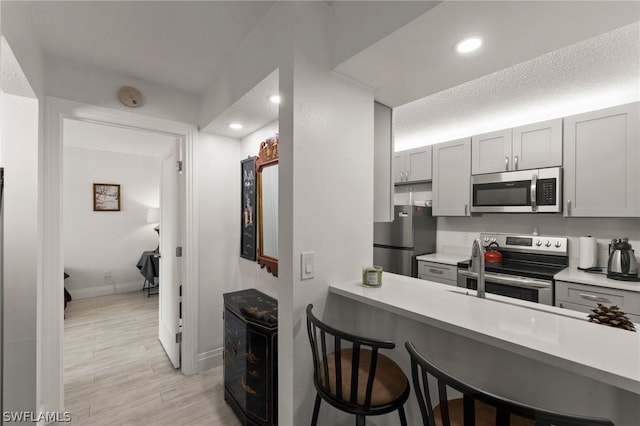 201 Santa Clara Dr Unit 13, Naples, FL 34104 - kitchen with light countertops, a kitchen breakfast bar, and stainless steel appliances