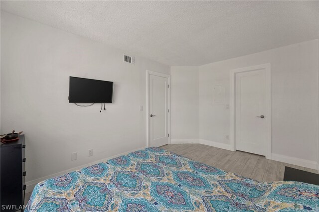 bedroom featuring hardwood / wood-style flooring and a textured ceiling