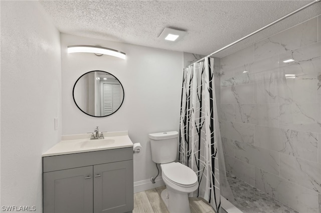 bathroom with oversized vanity, toilet, a shower with shower curtain, hardwood / wood-style flooring, and a textured ceiling