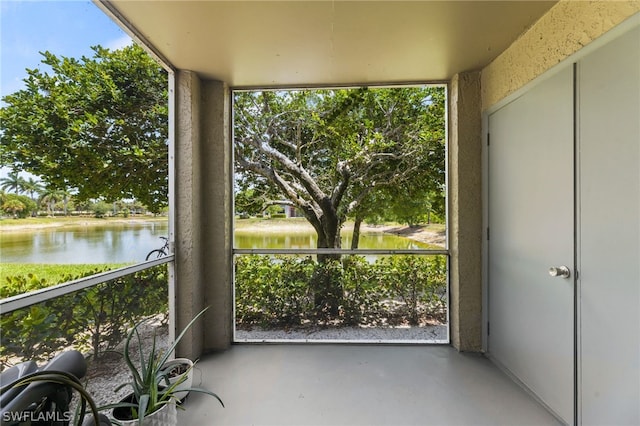 unfurnished sunroom featuring a water view