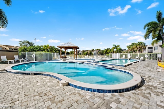 view of swimming pool featuring a patio area, a hot tub, and a gazebo