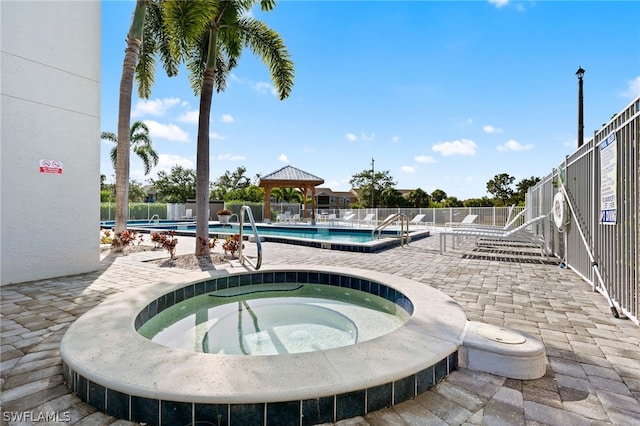 view of swimming pool with a community hot tub, a patio area, and a gazebo