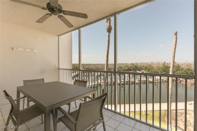 balcony featuring a water view and ceiling fan