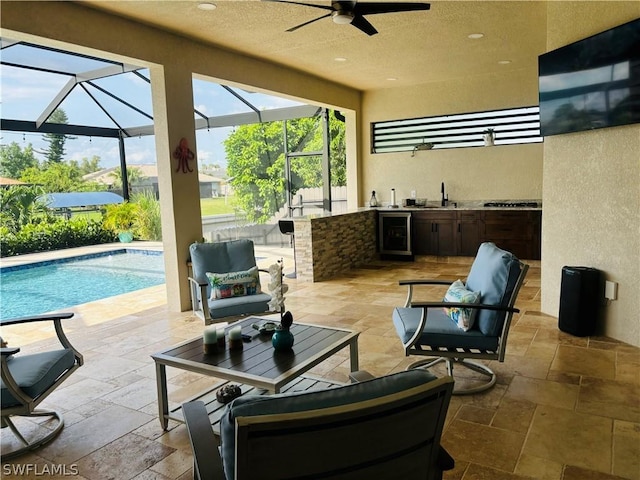 view of patio / terrace with an outdoor kitchen, a lanai, beverage cooler, an outdoor wet bar, and ceiling fan