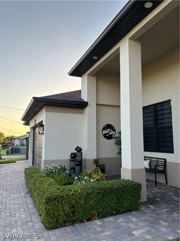 property exterior at dusk featuring a garage