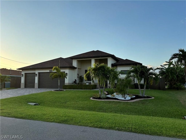 view of front facade featuring a lawn and a garage